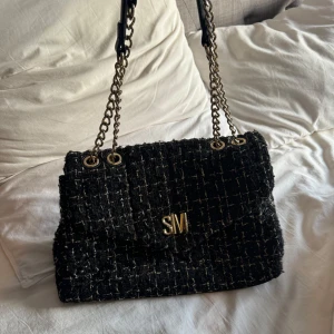 Svart quiltad axelväska med kedja - Säljer en snygg svart quiltad axelväska med guldfärgade kedjor och detaljer. Väskan kommer från Steve Madden. Perfekt för både vardag och fest! 🖤