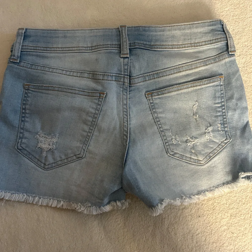 Säljer ett par ljusa jeansshorts från H&M i storlek 152. De har en snygg slitning och fransiga kanter för en avslappnad look. Perfekta för sommardagar och festivaler! 🕶️. Shorts.