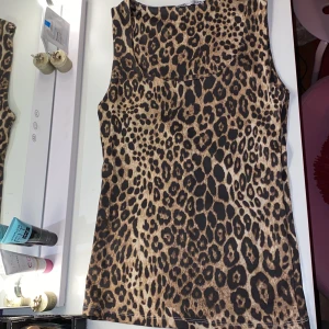 Leopardmönstrad ärmlös topp från Zara - DEN ÄR U-RINGAD!Säljer en snygg leopardmönstrad ärmlös topp från Zara i storlek S. Den finns inte hos Zara längre. Perfekt för en utekväll eller när du vill sticka ut lite extra. Toppen är i mycket bra skick och har en tight passform som framhäver figuren. Materialet känns mjukt och bekvämt mot huden. Jag köpte den från Zara här om dagen och när jag kom hem hade jag redan en likadan hemma. Det är inget fel på den alltså inga hål m.m.  Aldrig använt 
