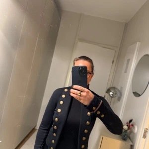 Marinblå kavaj från Ralph Lauren Denim & Supply - Marinblå kavaj från Ralph Lauren Denim & Supply med guldknappar i militärstil. Perfekt för höst och vår, med en normal passform och långa ärmar. Kavajen har en stilren design som passar både till vardags och fest. Ett måste i garderoben för den stilmedvetna! Nypris ca 4500:-