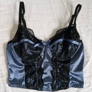 Blå spetstopp - Söt blå topp med svarta spetsdetaljer och rosett 🎀🖤 Glansigt, sidenliknande material. Reglerbara axelband och underbygel. Sann till storlek (S) Sparsamt använd, i mycket fint skick!  Pris är självklart förhandlingsbart 😊