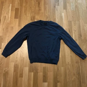 Blå tröja från H&M - Säljer en blå tröja från H&M i relaxed fit. Tröjan har långa ärmar och en rund halsringning, perfekt för en avslappnad stil. Passar bra till både jeans och chinos.