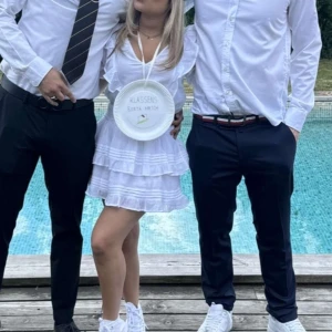 Vit klänning med volanger/Studentkläning  - Säljer en söt vit klänning med volanger och kort ärm. Klänningen har en smockad midja och flera lager i kjolen som ger en fin volym. Man kan använda den både bak och fram. Barnstorlek 152 men är mer som XS/S. Perfekt till studenten och för sommarens alla tillfällen! 💫