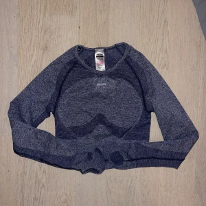 Marinblå långärmad topp och leggings från Gymshark - Säljer ett set med en mörkblå långärmad topp och matchande leggings från Gymshark. Toppen är croppad och har en tight passform med tumhål vid ärmsluten. Leggingsen har en hög midja och är också i en tight passform. Perfekt för träning och aktiva dagar. Tröjan är i M och tightsen är i S. Båda delarna för 300kr. 