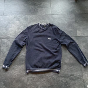 Mörkblå tröja från Hugo Boss - Snygg mörkblå tröja från Hugo Boss. Använd ungefär 10 gånger så den är i bra skick. 