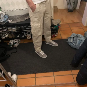 Beige cargobyxor från Bershka - Säljer ett par snygga beige cargobyxor från Bershka. Byxorna har flera praktiska fickor och en avslappnad passform. Perfekta för en casual look. Tillverkade i ett bekvämt material.
