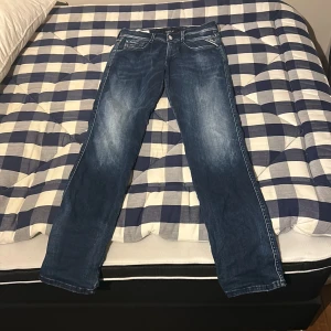 Blå jeans från Repaly  - Snygga blå jeans från Replay med en klassisk straight fit. De har en lätt slitning framtill och bakfickor med dekorativa sömmar. Perfekta för en avslappnad stil.