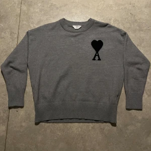 Ami paris stickad tröja  - Säljer en stilren grå tröja från Ami Paris. Tröjan är i 9/10 skick knappt använd armarna va lite för korta för mig annars har den inga defekter priset går gärna att diskuteras 