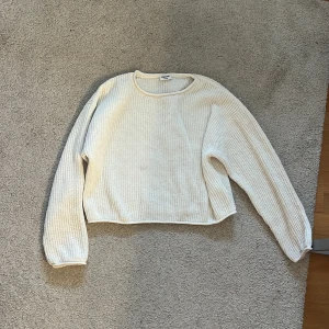 Vit stickad tröja från Kappahl - Mysig vit stickad tröja från Kappahl med rund hals och långa ärmar. Perfekt för kyligare dagar och enkel att matcha med olika outfits. Tröjan har en klassisk design som aldrig går ur stil.