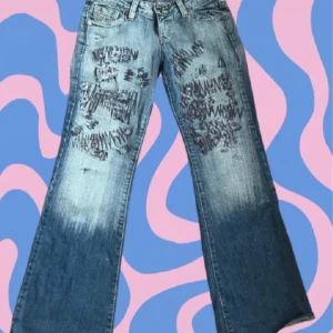 Unika jeans med slitningar - Snygga blå jeans med unika slitningar och broderade detaljer. Från liloustockholm, kommer tyvärr inte till användning. Bootcut, midjemått: 40cm, innerbenslängd: 77cm