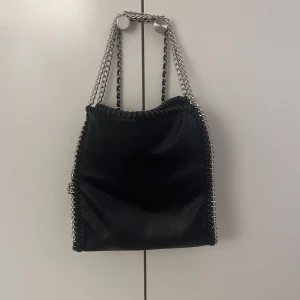Svart axelväska med kedjedetaljer - Väska från Gina, super bra skick bara använd ett par gånger. Ny pris 330 kr