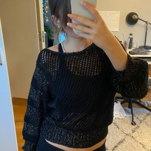 Svart glittrig nättröja - Säljer en supercool svart nättröja med glittriga detaljer. Perfekt för fest eller en utekväll! Tröjan är lite croppad och har långa ärmar. Den är både bekväm och stilren, och ger en edgy look. Passar perfekt över ett linne eller en bralette. 🖤✨