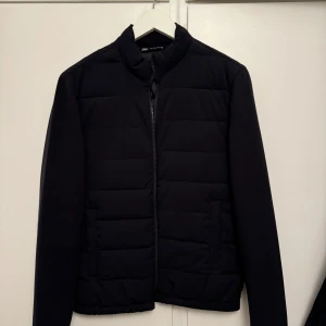 Svart cardigan Zara - Säljer en stilren svart cardigan från Zara i mycket bra skick. Den är långärmad och har en enkel design som passar till det mesta. Perfekt för dig som vill ha en lätt och bekväm jacka som passar till allt!