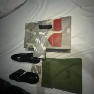 Valentino Garavani rockrunner - Säljer ett par snygga svarta sneakers från Valentino Garavani i nytt skick. Skorna har en stilren design med snörning och är tillverkade i en kombination av skinn och mocka. Perfekta för både vardag och fest! Kommer med originalförpackning och dustbag.