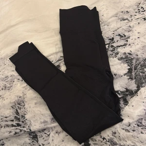 Svarta leggings från New Apparel - Säljer ett par svarta leggings från New Apparel i storlek XS. De är tillverkade av 96% polyamid och 4% elastan, vilket gör dem superstretchiga och bekväma. Perfekta för träning eller en avslappnad dag hemma. Högmidjade för en snygg passform! Men skulle säga att de är i storlek XXS 🩷