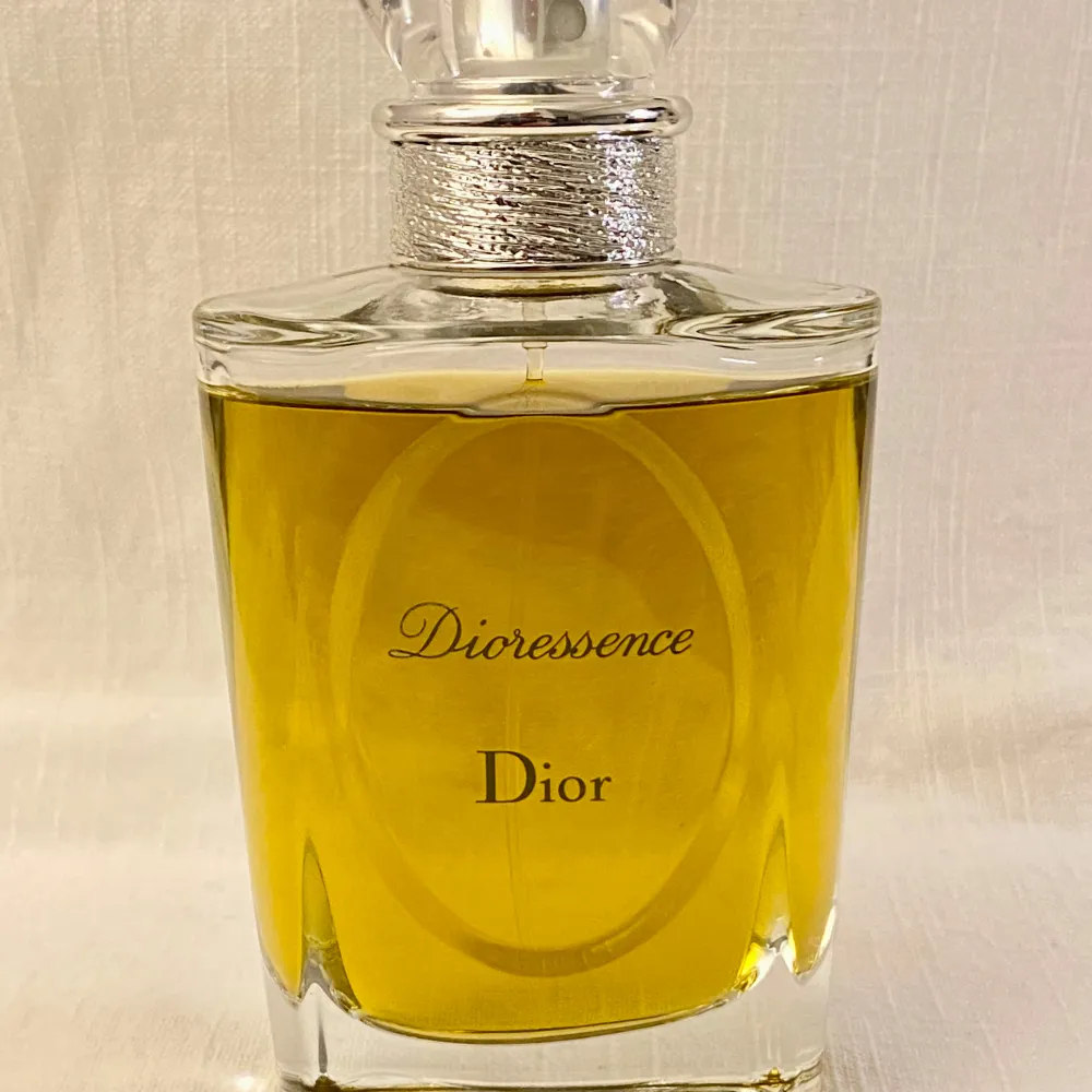 Säljer en elegant flaska Dioressence Eau de Toilette från Dior. Doften är varm och kryddig med inslag av patchouli, kanel och ros. Flaskan är stilren med en klar design & transparent kork .Perfekt för den som älskar klassiska och tidlösa dofter. Ett spray räcker! Nypris 1560kr. Parfym.