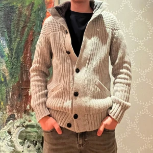 Grå stickad kofta från Ted Baker - Säljer en snygg och varm grå stickad kofta från Ted Baker. Den har en trendig fur lining krage med mörkare foder och knappar framtill. Perfekt för kyliga dagar och passar både till vardags och lite finare tillfällen. Två praktiska fickor fram. Skön och stilren design. Nypris runt 3200kr