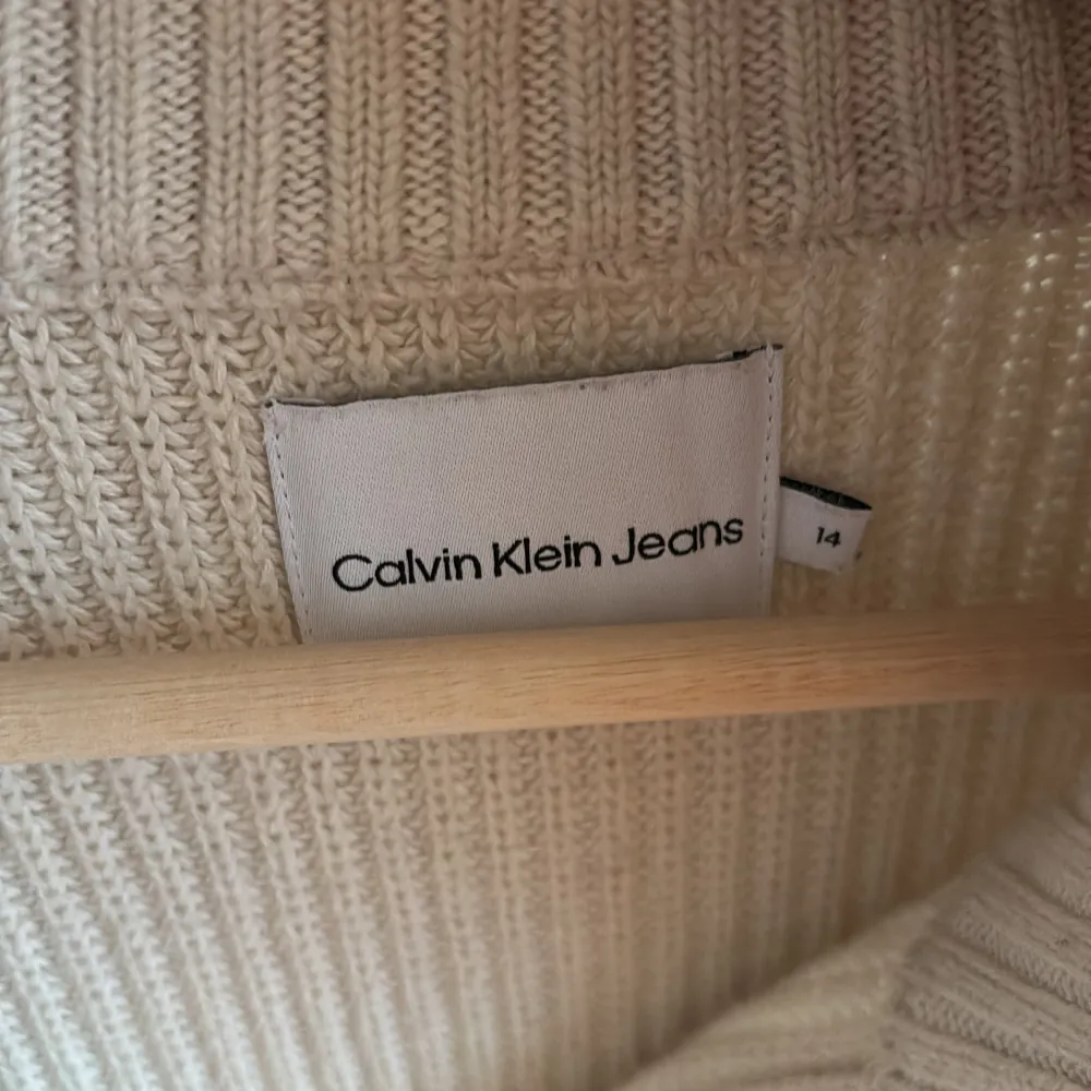 Säljer en snygg beige stickad tröja från Calvin Klein Jeans. Den har en dragkedja vid halsen och ett stilrent CK-märke på framsidan. Supermysig och i bra skick! Köpt för 800 kr. Tröjor & Koftor.