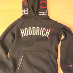 Hoodrich tröja  - Säljer en svart hoodie från Hoodrich med  loggan på bröstet och coola detaljer på huvan. Perfekt för vintern eftersom den är varm och bekväm i insidan och passar perfekt  till både vardag och chill . Den är  i  mycket bra skick utan skador. Skön och stilren, perfekt för höst och vinter!