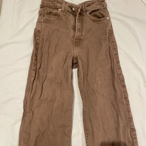Bruna jeansbyxor - Säljer ett par bruna jeansbyxor i bra skick. De har en klassisk femficksdesign och är tillverkade i ett slitstarkt material. Perfekta för vardagsbruk och kan enkelt matchas med olika toppar. Passar bra för höst och vår.