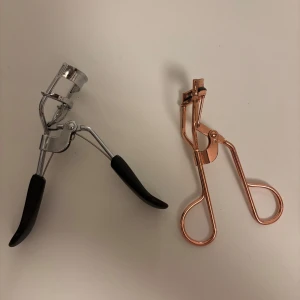 Ögonfransböjare i silver och roséguld - Två stiliga ögonfransböjare, en i klassisk silver med svarta handtag och en i trendig roséguld. Perfekta för att ge dina fransar en vacker böj och lyft. De ergonomiska handtagen gör dem bekväma att använda. Perfekt för både vardag och fest! 1 för 10