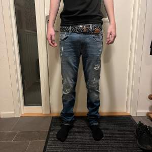 Säljer ett par snygga blå jeans från Replay i modellen Anbass. De är i mycket bra skick med feta slitningar. Modellen är 180 och väger 63. 