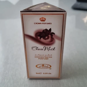Choco Musk Concentrated Perfume från Crown Perfumes - Säljer en koncentrerad parfym med doften Choco Musk från Crown Perfumes. Flaskan innehåller 6 ml och kommer i en elegant förpackning med bruna och vita detaljer. Perfekt för dig som älskar en söt och varm doft med inslag av choklad och mysk. Liten och smidig att ta med sig överallt!