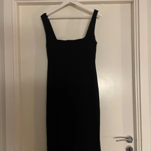 Svart klänning från Zara - Snygg svart klänning från Zara i storlek L. Den har en elegant och enkel design med breda axelband och en tight passform som framhäver figuren. Perfekt för både fest och mer formella tillfällen. Klänningen är i mycket bra skick, inga anmärkningar! Den når till strax över knäna på mig som är 171cm 💫