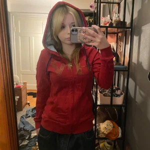 Fin röd zip up hoodie - Super fin hoodie med glansiga stenar på framsidan❤️tyvärr har den en fläck där framtill men skulle gissa den går bort om du tvättar de noga❤️