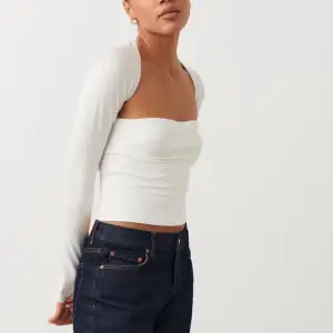 Säljer en snygg vit offshoulder topp från Gina Tricot i storlek S. Toppen är croppad och har långa ärmar, perfekt för både vardag och fest. Materialet är mjukt och stretchigt, vilket gör den bekväm att bära. Passar perfekt till jeans eller kjol för en stilren look.