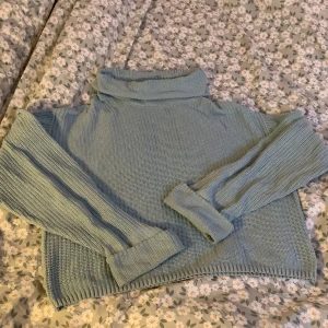 Ljusgrön stickad polotröja från Lindex - Mysig ljusblå stickad polotröja från Lindex, Perfekt för kyliga dagar. Tröjan är i storlek 146/152. Den är både stilren och bekväm, idealisk för höst och vinter.