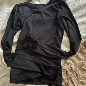 Svart långärmad topp - Säljer en stilren svart långärmad topp i mycket bra skick med tumhål! Perfekt för både vardag och fest. Materialet känns mjukt och skönt mot huden. 