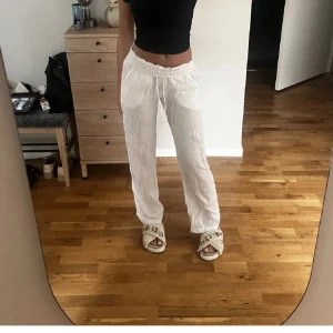 Vita linnebyxor - Säljer ett par vita linnebyxor som är perfekta för sommaren. De har en loose passform och är högmidjade med en bekväm resår i midjan. 