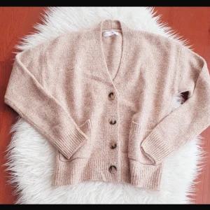 Supersnygg kofta - Mysig beige kofta i mjukt material med knappar framtill. Perfekt för kyliga dagar med sin ribbade kant och långa ärmar. Passar både till vardags och lite finare tillfällen. En klassisk och tidlös design som är lätt att matcha med andra plagg.💕