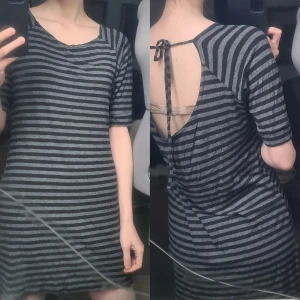 T-shirtklänning öppen rygg randig grå/svart - Fint skick. Inga lappar, men troligen HM, S-M, bomull/elastan. Stretchigt och mjukt tyg. Vidd: 43-50, längd: 77, ärmlängd: 35.