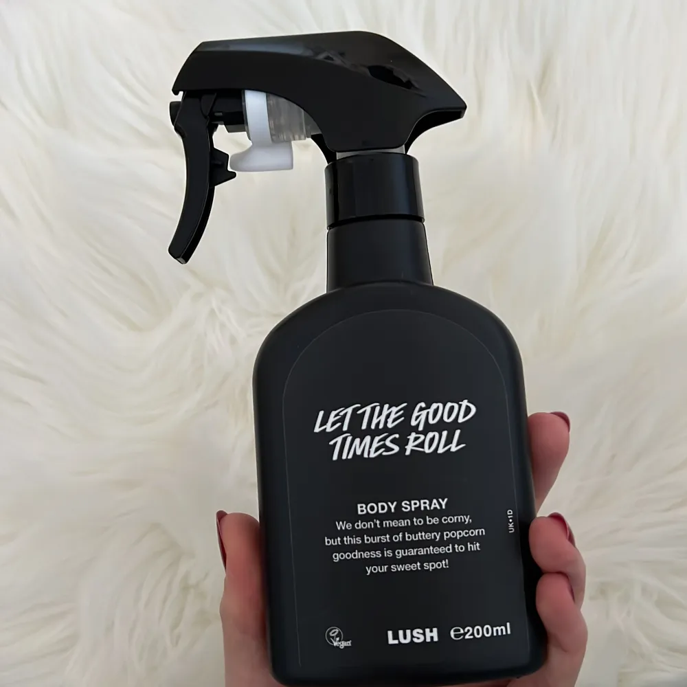 Säljer en 200 ml body spray från Lush med namnet 'Let The Good Times Roll'. Den har en söt och smörig popcorn-doft som verkligen sticker ut. Perfekt för dig som vill ha en unik och rolig doftupplevelse. Flaskan är svart med en praktisk sprayfunktion.. Parfym.