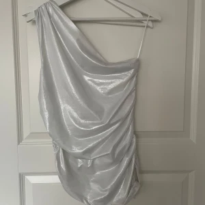 Glansig topp från H&M - Glansig one-shoulder topp från H&M med rynk längs sidorna