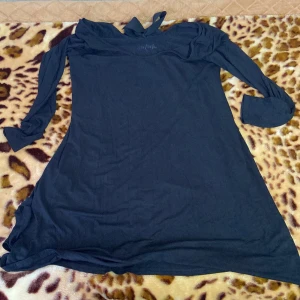 Svart långärmad klänning med knyt - Säljer en svart långärmad klänning med knyt i nacken. Perfekt för höst och vinter, den är både stilren och bekväm. Klänningen har en normal passform och är gjord i ett mjukt material. Passar bra till både vardag och festliga tillfällen.