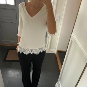 Vit trekvartsärmad topp med spets - Vit trekvartsärmad topp med fastsydd spets på insidan från Peace n’ Love i storlek S/M. Fint skick. Använd gärna köp nu!