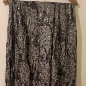 Scarf med silvriga detaljer  - Säljer denna då den inte kommer till användning längre.  Grå i färgen, med silvriga detaljer. I använt skick, men tycker den har mer att ge, därav det låga priset. Skavanker finns, men syns inte när man har den på sig.  Tror den är köpt på hm.