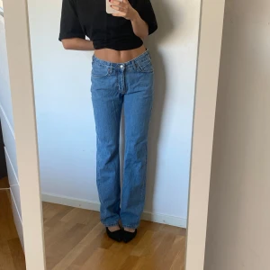 Raka lågmidjade jeans - Säljer dessa blåa raka jeans med låg midja från bikbok då de blivit för små och inte kommer till användning. Jättefint skick men använda. Lite slitna längst ner vid foten.💙 W: 26 L:32