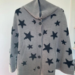 Mysig poncho - Mysig poncho, ledig passform, bekväm, stjärmönster svart och grått. Knappar framtill och fickor. Fint skick. 