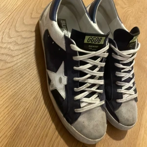 Golden goose  - Säljer dessa feta golden goose i fint skick förutom att hälen har börjat släppa lite men det kan fixas med lite lim. Storlek 43 men passar 44. Box tillkommer. Unik färg som kommer få mycket uppmärksamhet 