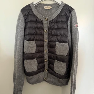 Moncler Cardigan Dam - Moncler Cardigan i storlek L passar mindre. Väldigt fint skick bortsett från ett litet lagat hål, syns inte när den är knäppt. Äkthetsbevis finns