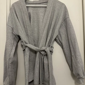 Kofta - Kofta i sweater material, med knytband. Stl XS. Använd 1 gång