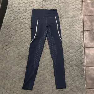 Maya Delorez ridbyxor - Säljer dessa marinblå maya delorez ridbyxorna i stl S. Helskodda. Dem är välanvända men bra skick. Lite av texten har försvunnit. Nypris: 900kr