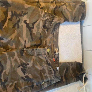 Camouflage cargobyxor från ONLY - Säljer ett par snygga camouflage cargobyxor från ONLY i storlek S. Byxorna har en cool militärlook med flera fickor och en bekväm passform. Perfekta för en avslappnad stil eller utomhusaktiviteter. De är i bra skick och redo för nya äventyr!