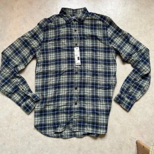 Helt ny Esprit skjörta strl S, 100% bomull med prislappen  - Helt ny en skjorta med rutiga mönster i blått, grönt och vitt. Den har en knappslå och en vanlig krage.  Storlek S 100% bomull  Regular