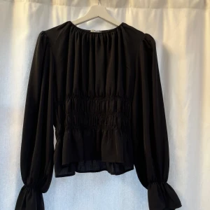 NAKD blus midjedetalj - Helt oanvänd blus från nakd med så fina detaljer vid midja och ärmarna. Man får verkligen så fin form av den. Använd gärna köp nu så försöker jag posta samma dag💕☺️