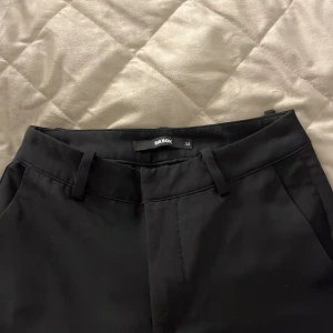 Svarta kostymbyxor från Bik Bok - Snygga svarta kostymbyxor från Bik Bok i storlek 34. Byxan är i modell short och är i bra skick.